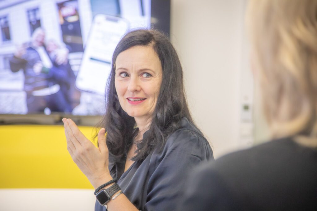 Bilde av smilende ansatt på kontoret til Alf Gundersen